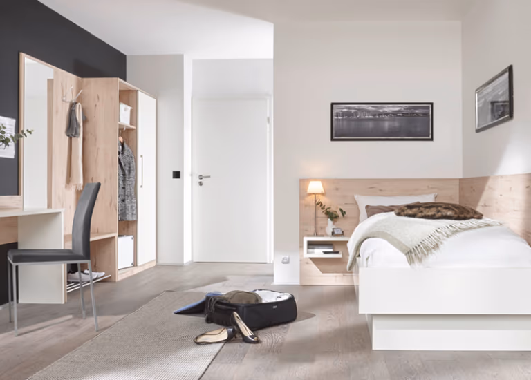 Helles Jugendzimmer mit Einzelbett, Kleiderschrank und Schreibtisch.